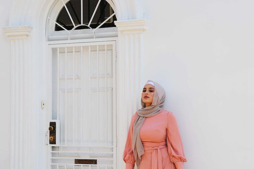 Hijabi model Nawal Sari poses in pink dress for Hijab House Photoshoot to depict modest fashion trend.