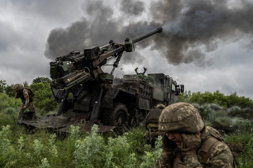 Ukrainian service members fire a Caesar self-propelled howitzer towards Russian troops.