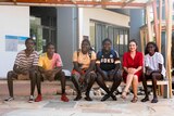 Five Aboriginal students and a teacher sitting on a bench