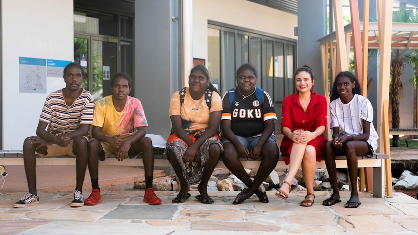Five Aboriginal students and a teacher sitting on a bench