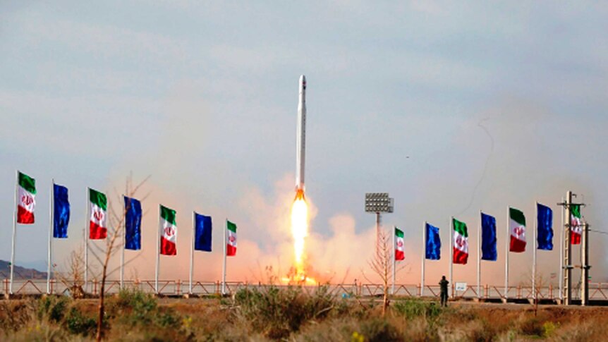 A rocket is being launched surrounded by flags.