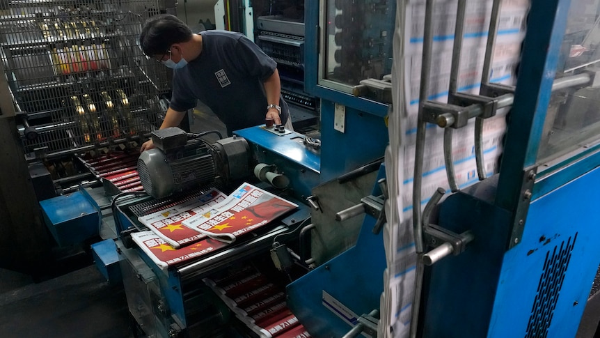 A worker checks copies of Apple Daily
