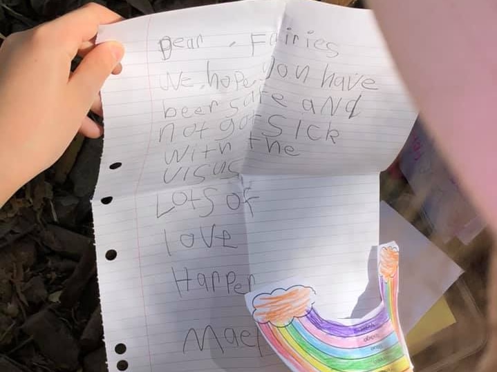 A little girl holding a handwritten letter.