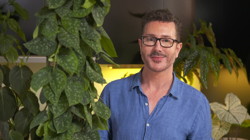 Craig Miller-Randle poses with indoor plants grown on totems, bulked up with propagation. 