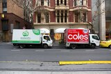 A Coles and Woolworths delivery trucks parked together in Collins Street, Melbourne