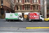 A Coles and Woolworths delivery trucks parked together in Collins Street, Melbourne