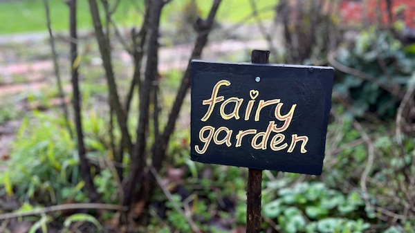 A 'Fairy Garden' sign in a garden.