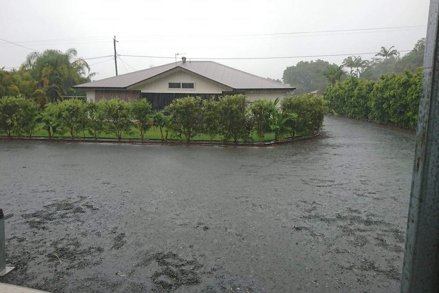 A street in Cooloola Cove received heavy rain overnight, road covered with water.