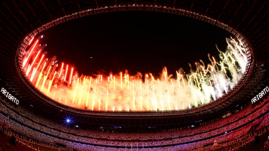 Fireworks go off at the end of the Olympics closing ceremony as the word "Arigato" (thank you) appears on the screens.