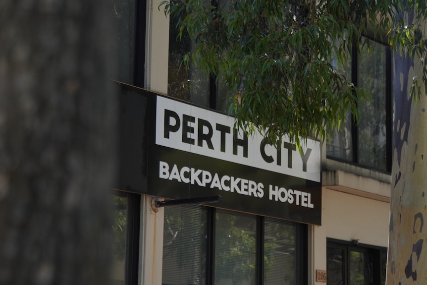 A sign on the front entrance of a backpackers hostel
