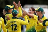 A group of Australian female cricketers celebrate a wicket