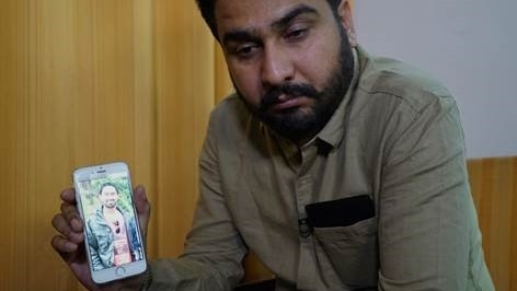 Manmeet Alisher's brother Amit, enroute to Brisbane, shows a photo of Manmeet on his phone.