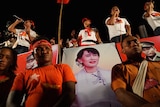 Supporters hold posters of opposition leader Aung San Suu Kyi