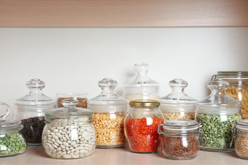 Neatly organised jars on a pantry shelf.