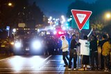 Members of a rowdy group of demonstrators stand with a road sign in Ferguson