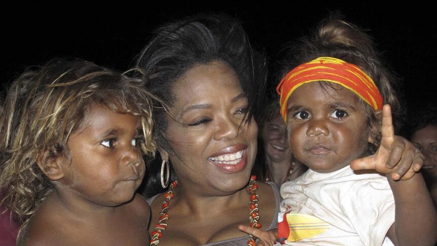 Oprah Winfrey holds two children