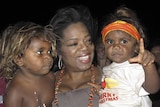 Oprah Winfrey holds two children