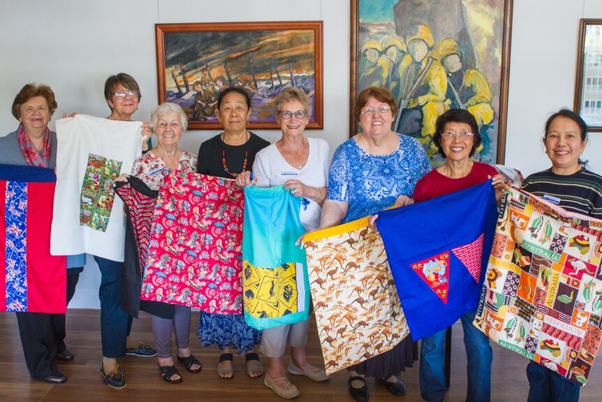 Ladies in a group holding laundry bags.