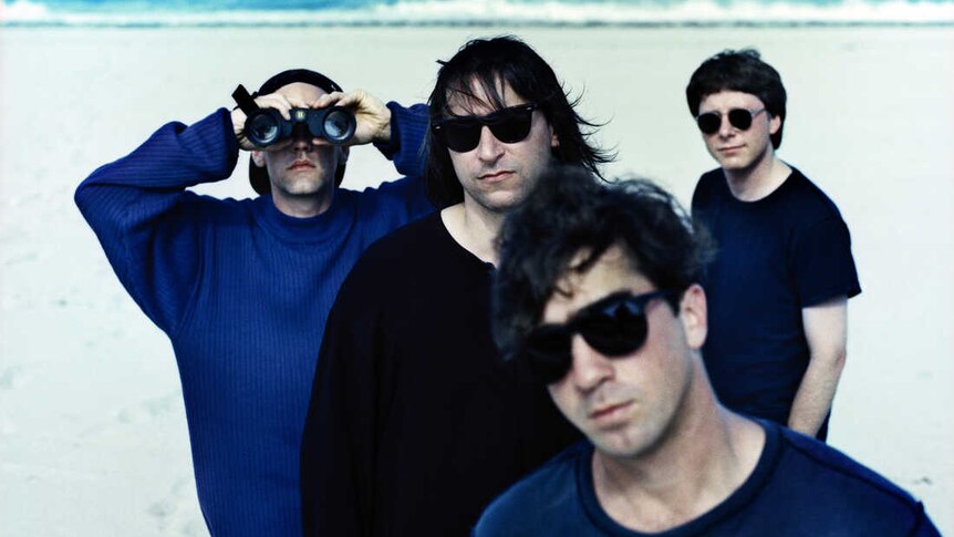 A 1992 photo by Anton Corbjin of R.E.M. on a beach dressed in blue