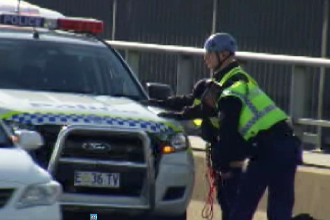 Animal rights protester frisked before being taken away, Tasman Bridge.