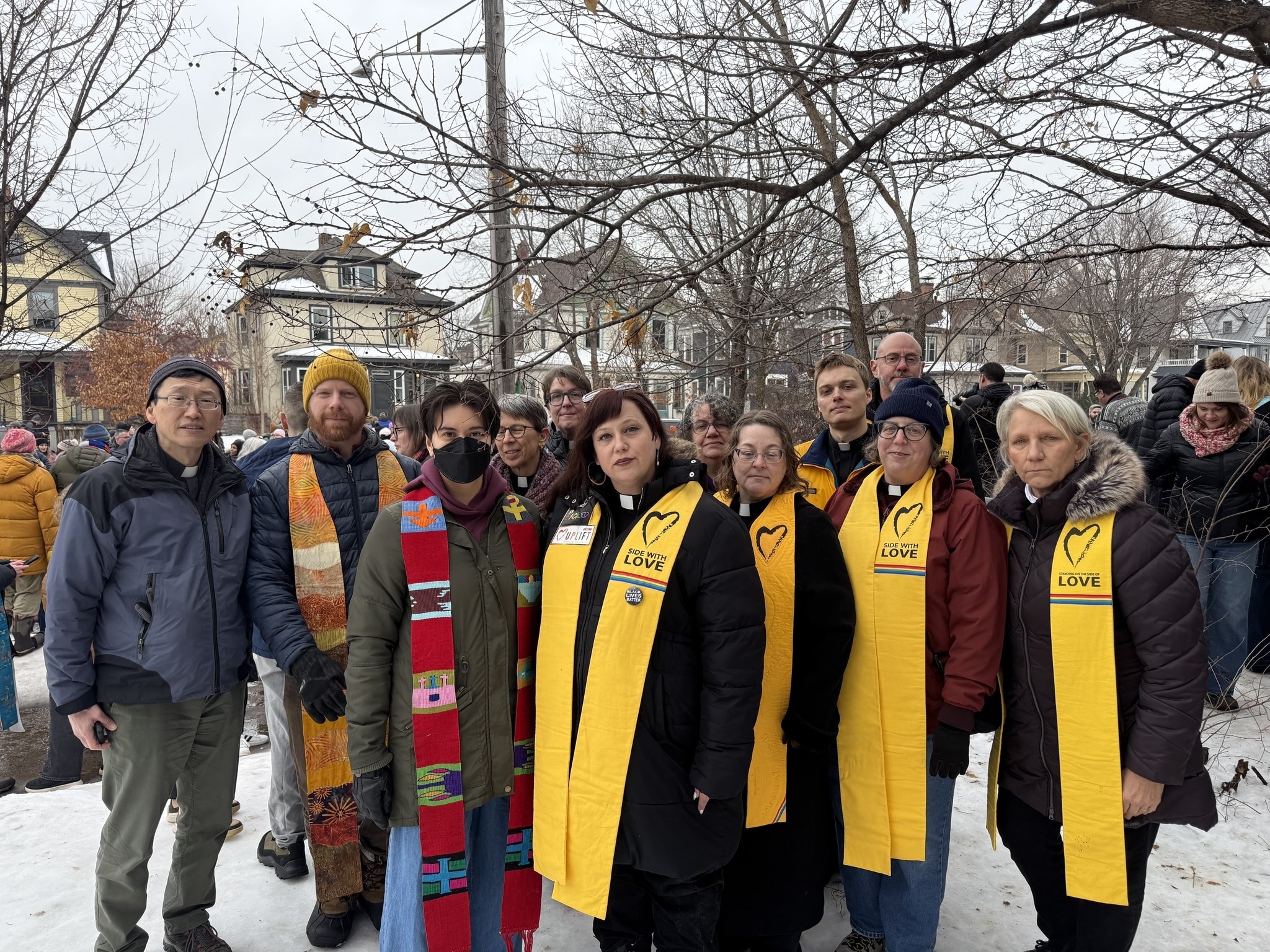 A group of women and men stand outside in the snow.