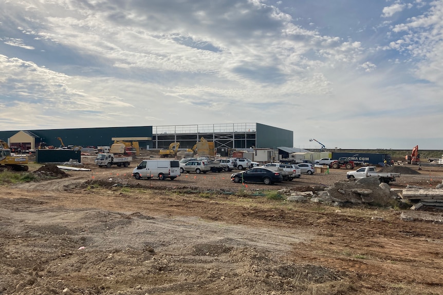 A building site with many cars and a half-built venue.