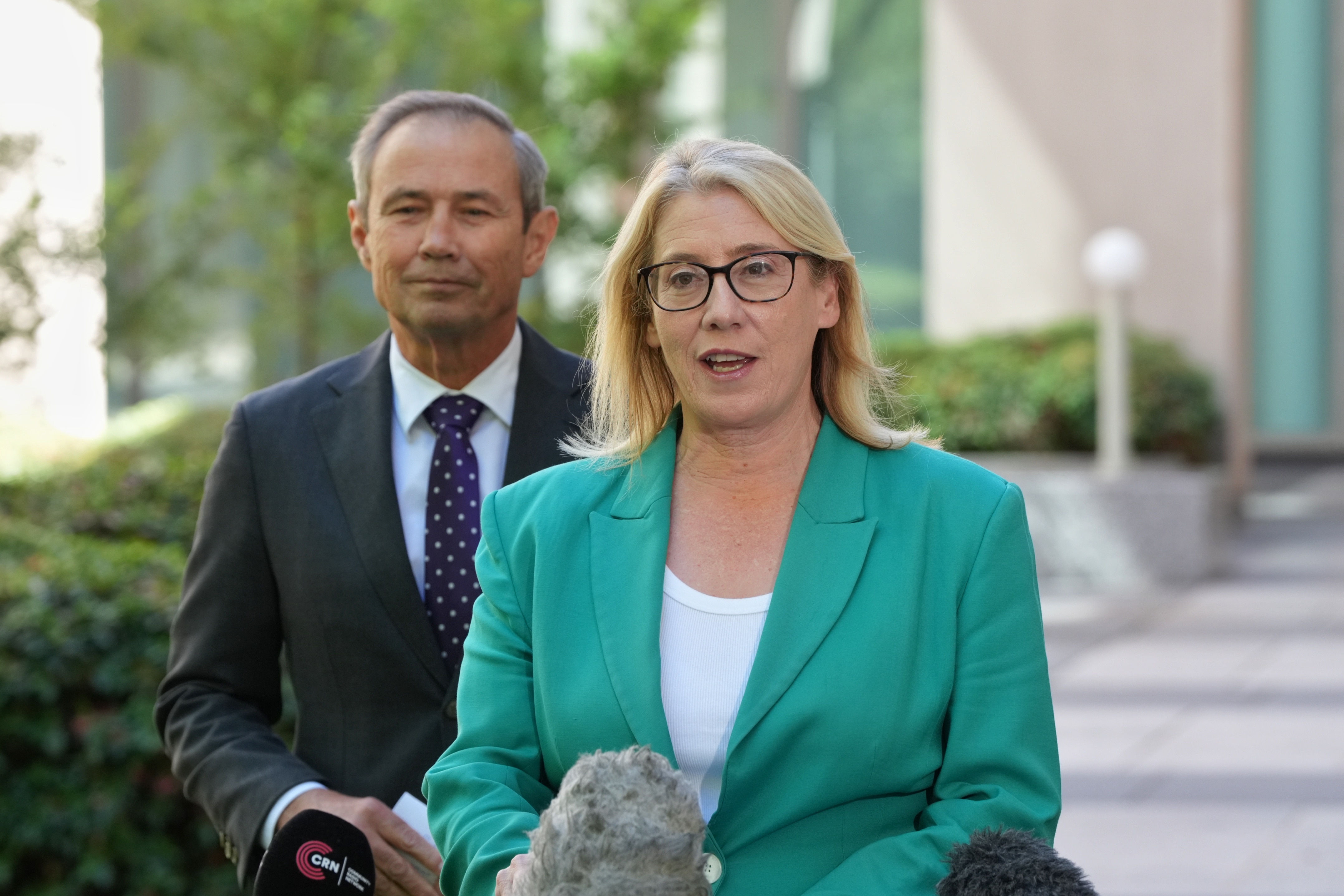 Rita Saffioti speaking with Roger Cook standing behind her.