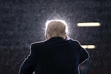 The back of Donald Trump as he speaks during a campaign rally in the rain
