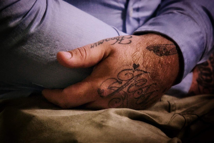 Close-up of tattooed hands.
