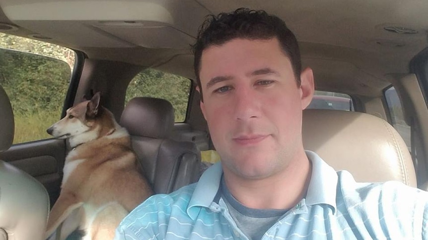 Adrian Murfitt takes a selfie in the car with his dog on the back seat