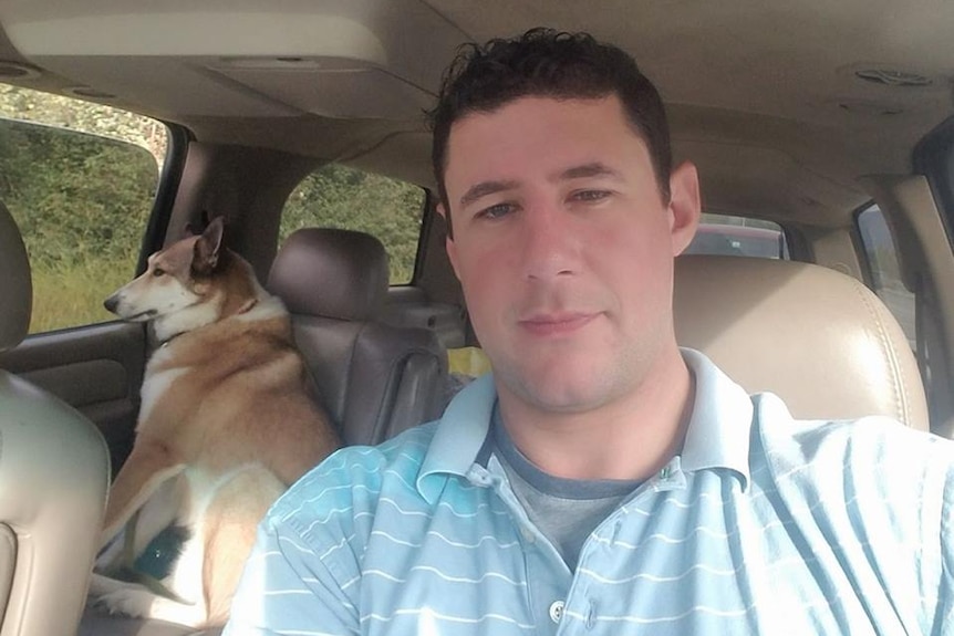 Adrian Murfitt takes a selfie in the car with his dog on the back seat