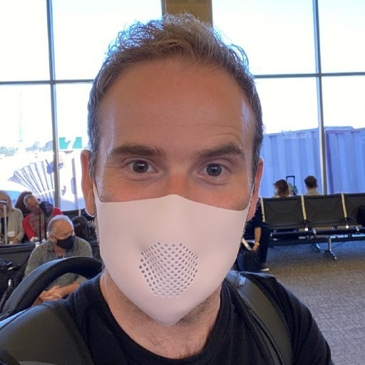 A man wears a silicone mask with a filter.