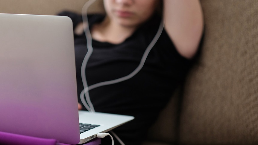 Unidentified young person using a laptop.