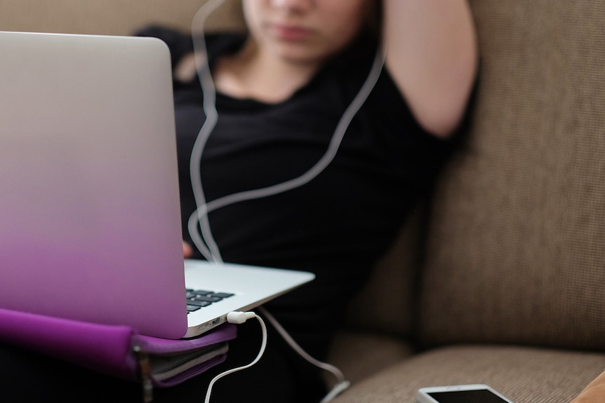 Unidentified young person using a laptop.