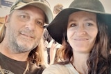 Two people, wearing hats, smile in a selfie