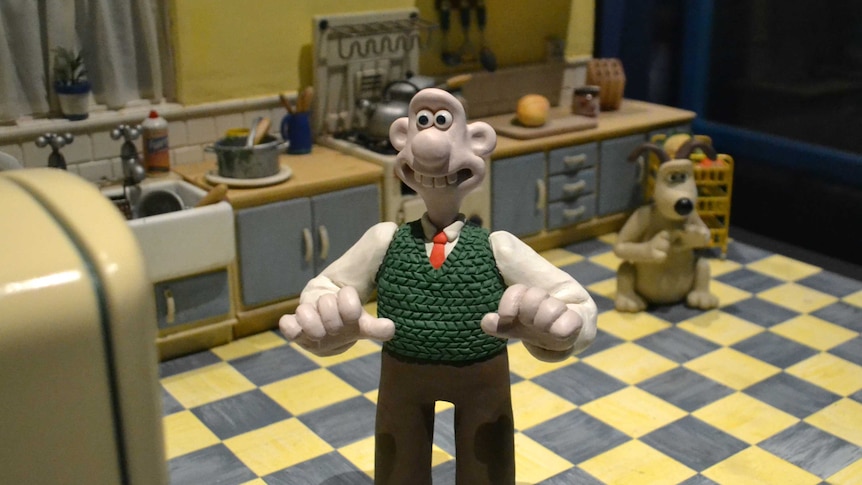 Wallace from Wallace and Gromit standing looking at fridge.
