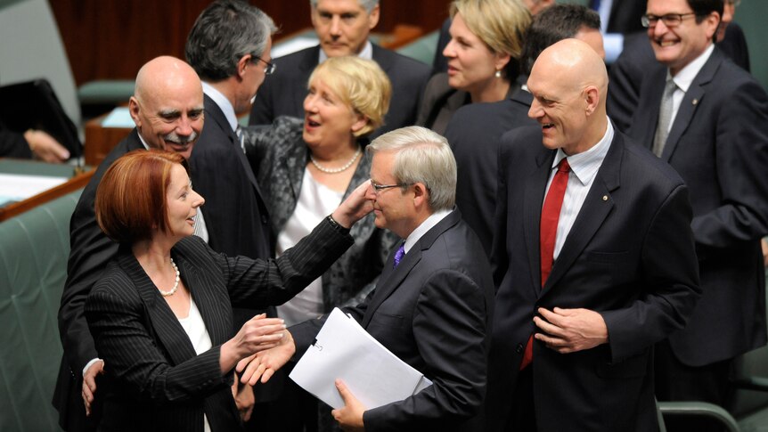 Julia Gillard hugs and kisses Kevin Rudd after the carbon tax legislation was passed (AAP: Alan Porritt)