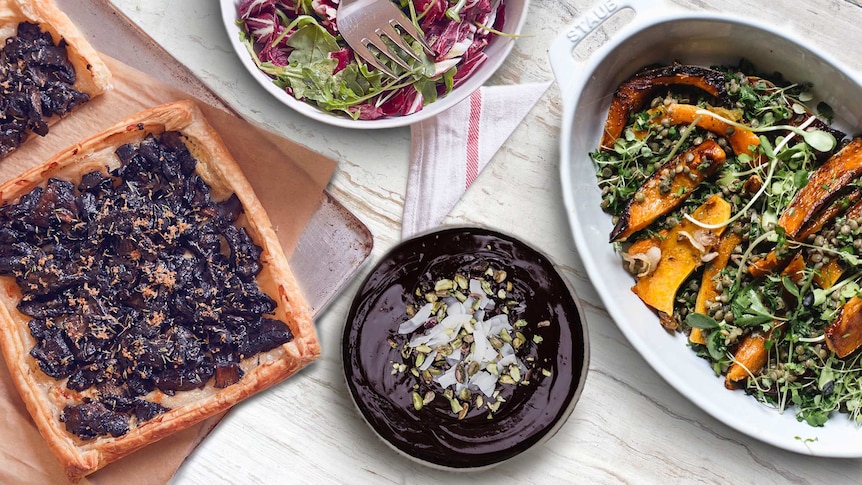 Overhead shot of pumpkin lentil salad, chocolate cake, mushroom tart and salad on a table.