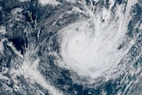 A satellite image of the South Pacific shows a portion of the Earth covered by a large cyclonic storm.