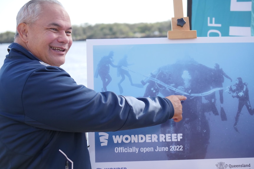mayor pointing to picture of him underwater
