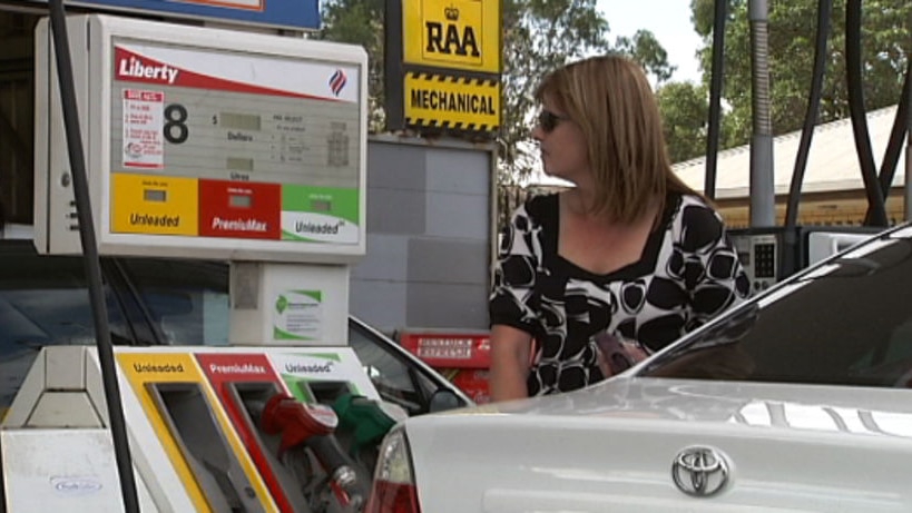 A woman fills up at a petrol station