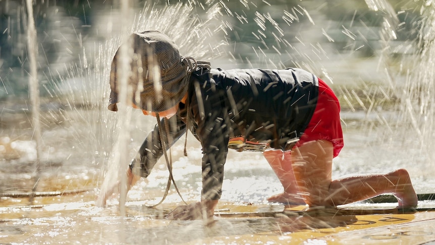 A child plays at water spray park at Brisbane's South Bank parklands on a hot day