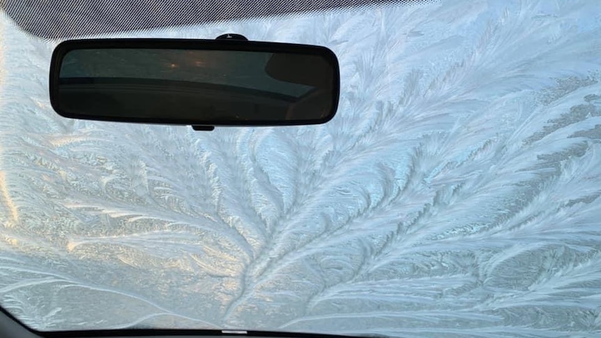 Frost patterns on the windscreen of a car as seen from the inside.