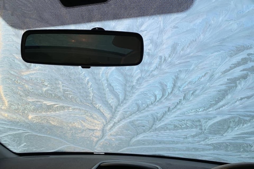 Frost patterns on the windscreen of a car as seen from the inside.