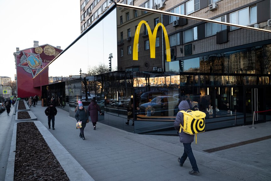 La gente pasa frente a un restaurante McDonald's en la calle principal de Moscú, Rusia.