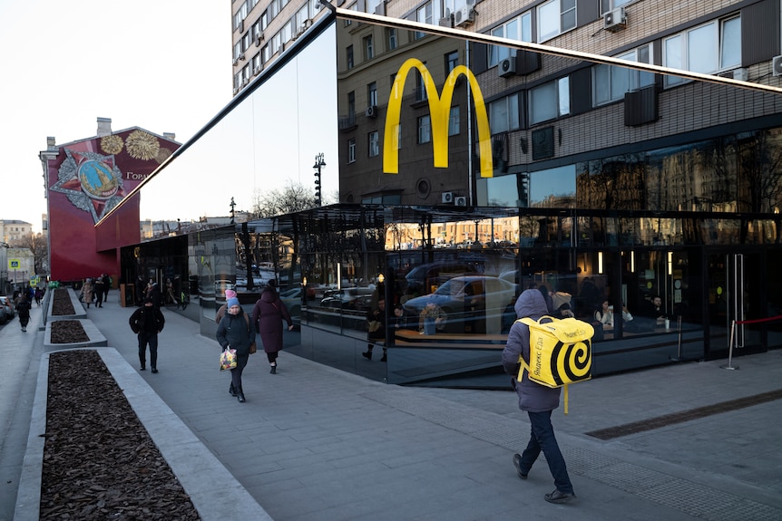 La gente pasa frente a un restaurante McDonald's en la calle principal de Moscú, Rusia.