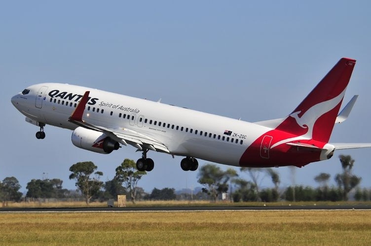 A red and white Qantas jet flies off the tarmac on a hot day in Victoria