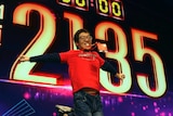 A staff member jumps in front of a screen saying 2135