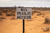 A sign reading 'No public access' stands in front of bushland