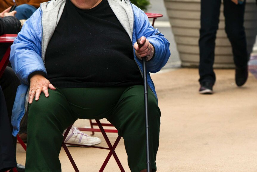 An overweight person sitting down.